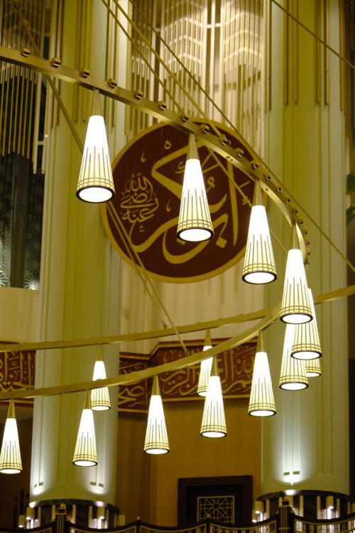 Free Beautiful mosque interior with hanging lamps and Arabic calligraphy. Stock Photo