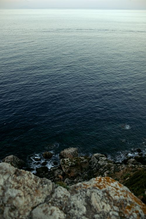 Free Serene view of ocean waves and rocky cliff, perfect for nature lovers. Stock Photo