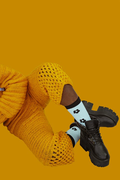 Fotos de stock gratuitas de botas negras, fondo amarillo, tiro vertical