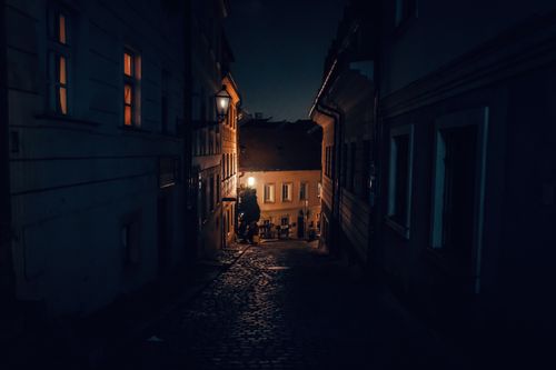 Free Charming cobblestone street in Bratislava is warmly lit by streetlights on a quiet night. Stock Photo