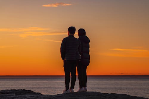 Free Photo of Couple standing on a Rock near Ocean Stock Photo