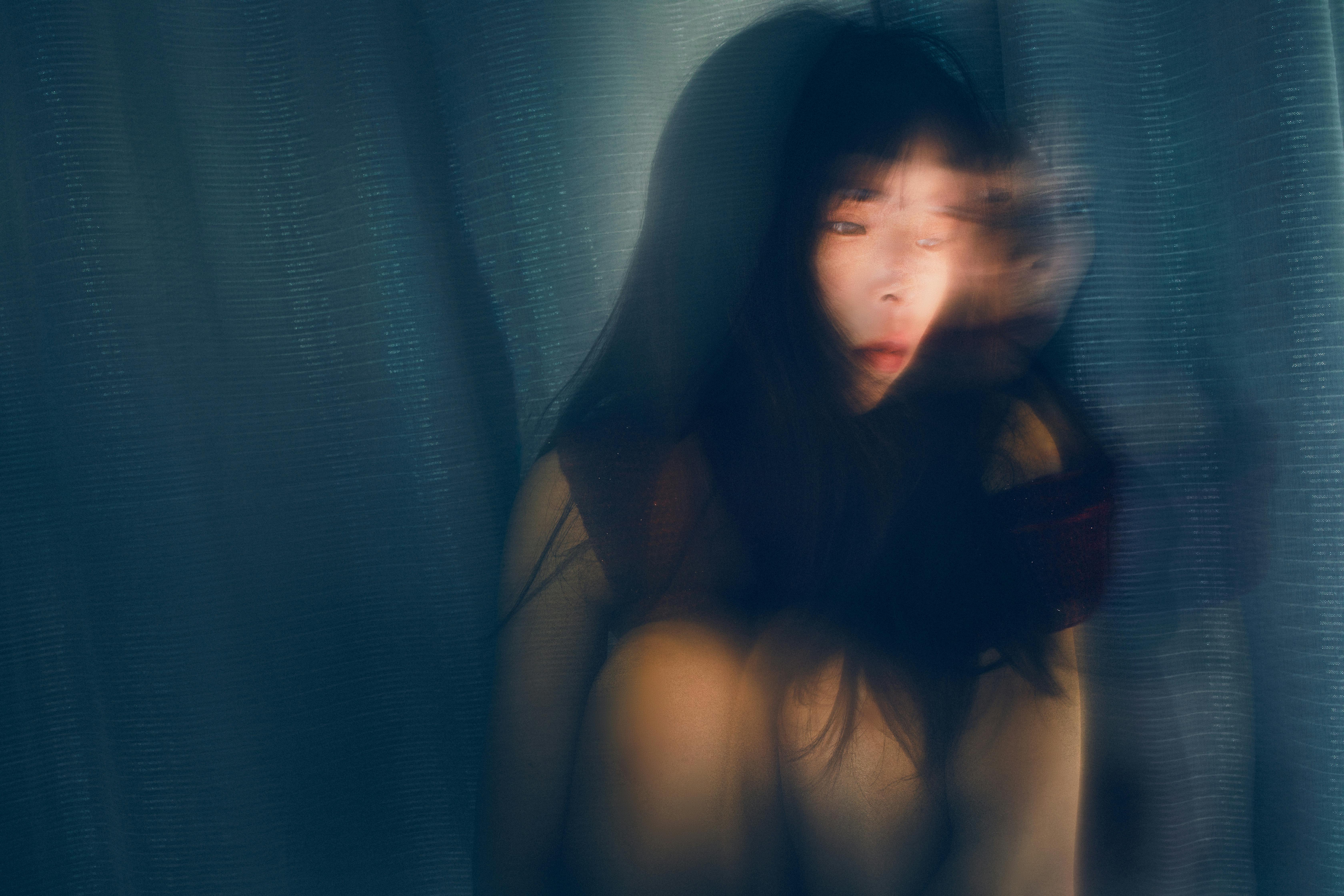 Artistic photo of a woman with a double exposure effect, creating a mysterious impression.