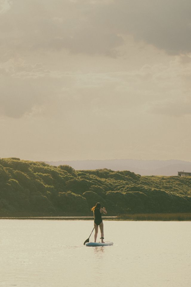 Mujer practicando paddle surf en aguas tranquilas en La Pineda