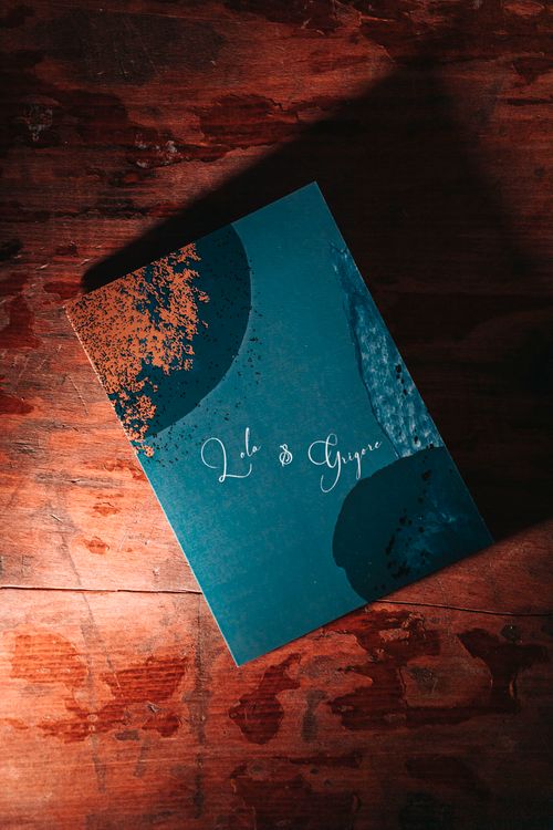 Free A stylish artistic wedding invitation card placed on a textured wooden surface with warm lighting. Stock Photo