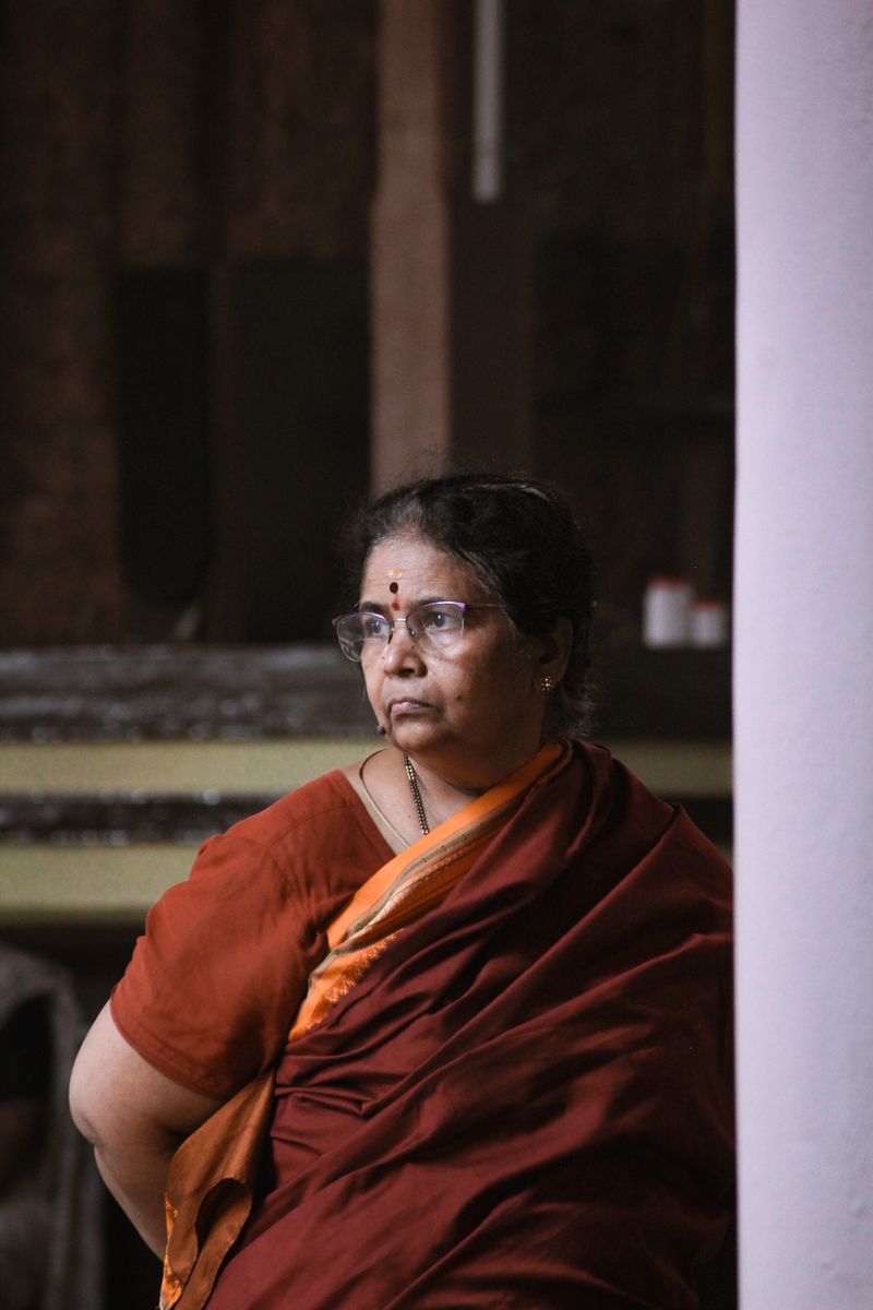 Sophisticated elderly Indian mother in a silk sari with glasses