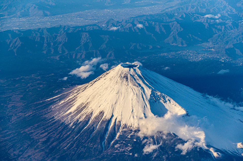 Stunning aerial view of snow-capped Mount Fuji, showcasing its volcanic beauty.