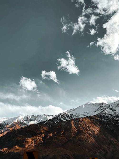 Бесплатное стоковое фото с голубое небо, горный пик, заснеженная гора