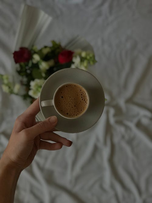 Top View of Hand Holding Coffee Cup