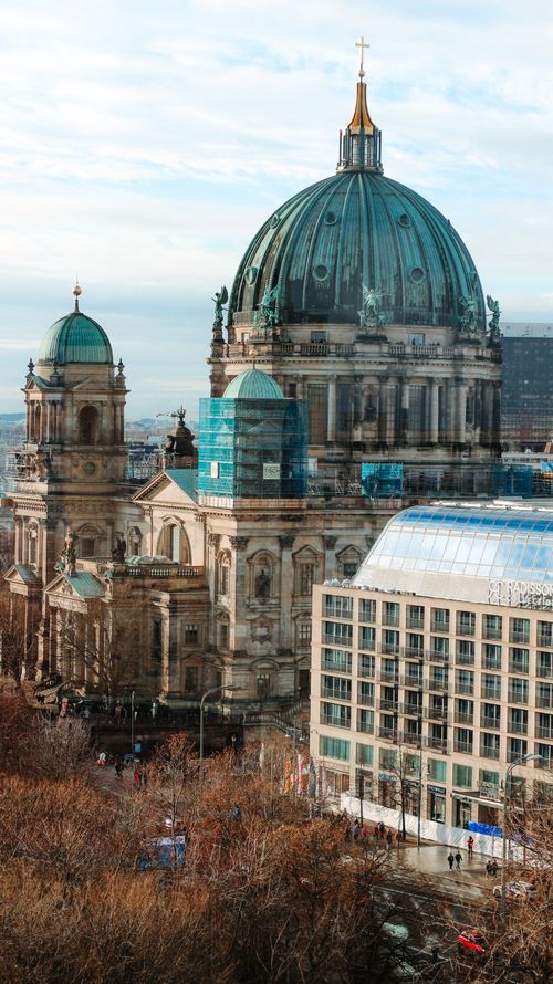 Free A stunning aerial view of Berlin Cathedral surrounded by autumn foliage, capturing historical architecture. Stock Photo