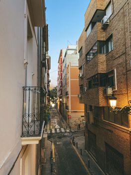 Picturesque city street in Alicante at dusk with traditional buildings and balconies.