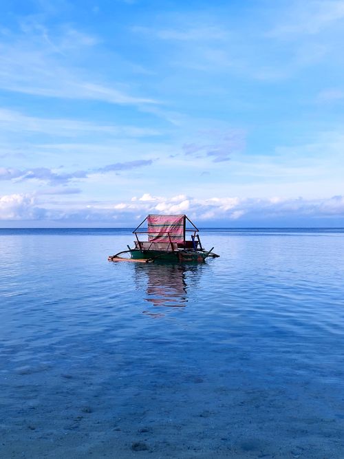 Free A tranquil view of a traditional bamboo raft on the clear blue waters of the Philippines. Stock Photo