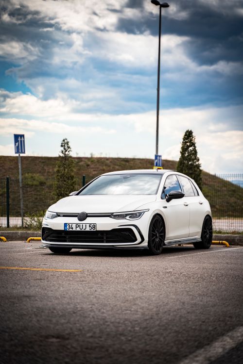 Free Sleek white hatchback parked outdoors on a cloudy day, front view. Stock Photo