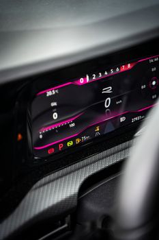 Detailed image of a digital car dashboard showing speed, temperature, and warning lights.
