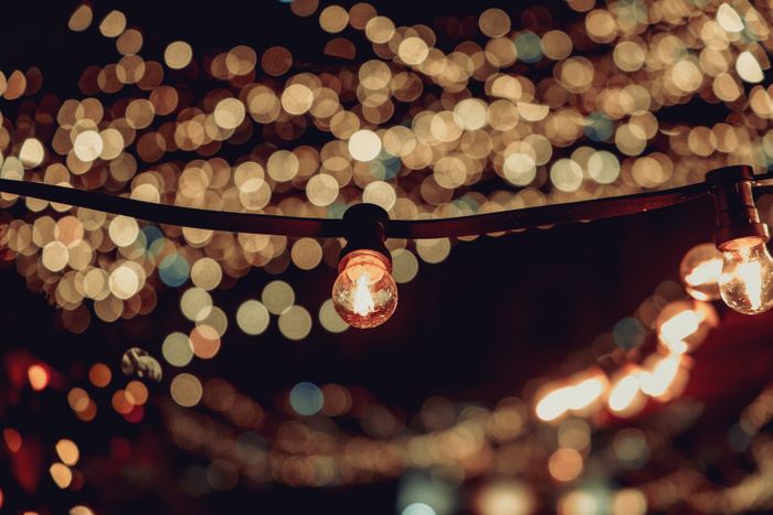 Bokeh of illuminated string lights at an evening event
