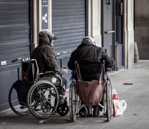 Free Two senior adults in wheelchairs socializing outdoors in winter attire. Stock Photo