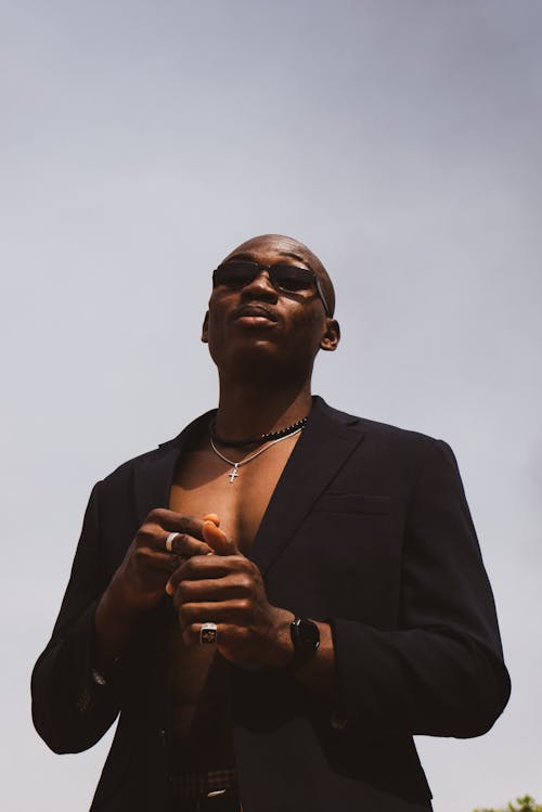 A man in a suit and sunglasses standing in the sun