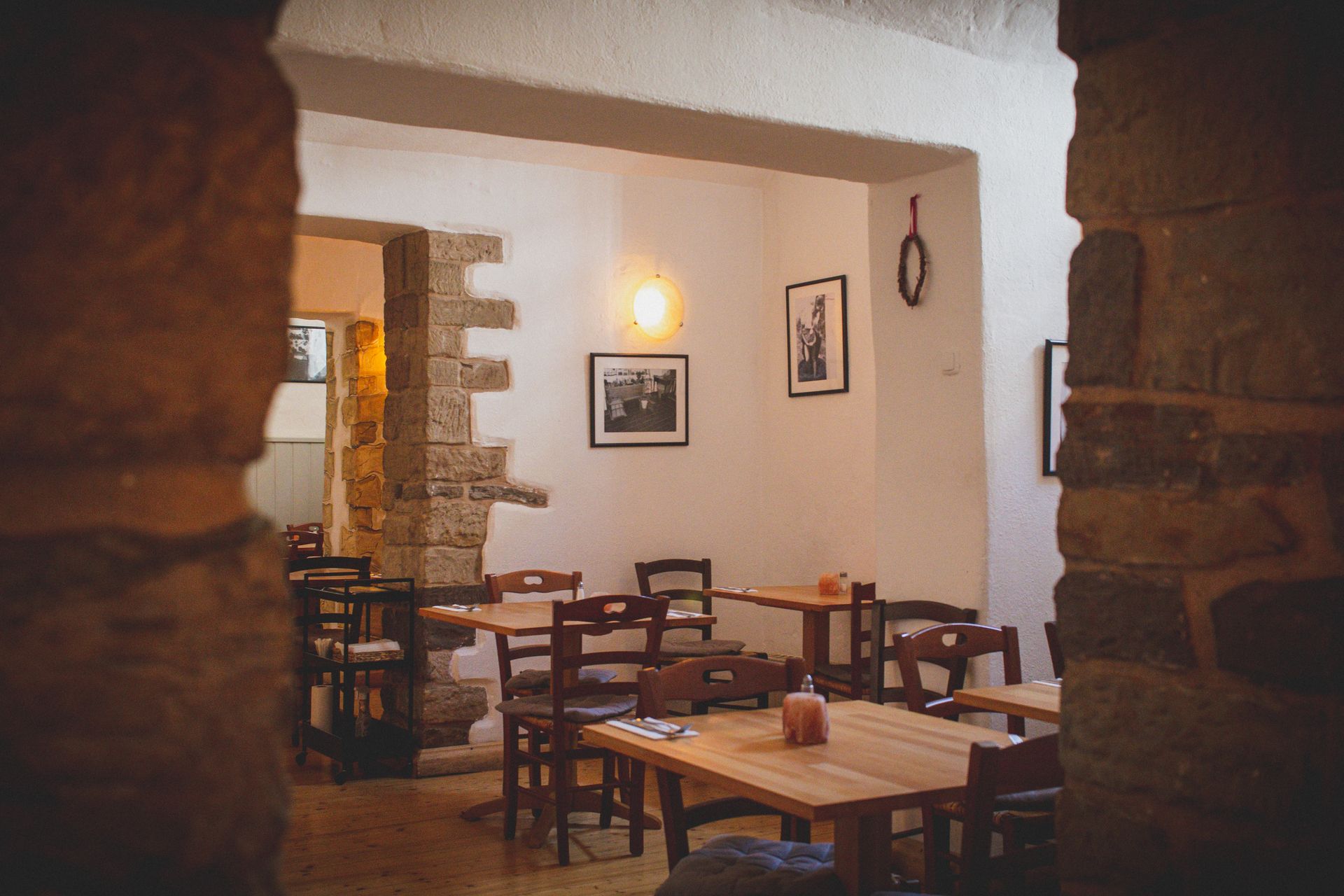 Warm and inviting small restaurant interior with rustic wooden furniture and soft ambient lighting, no people visible