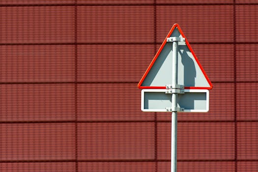 A minimalist photo of a traffic sign against a geometric red building facade.