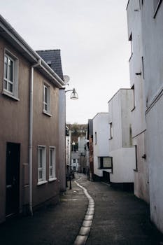 Explore a quaint narrow alley lined with residential buildings, perfect for urban lifestyle imagery.