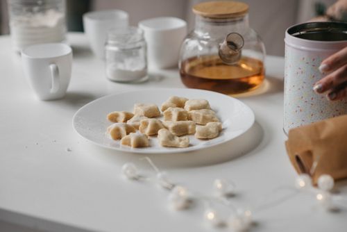 Free A warm, inviting scene showcasing cookies and tea on a minimalist white table. Stock Photo