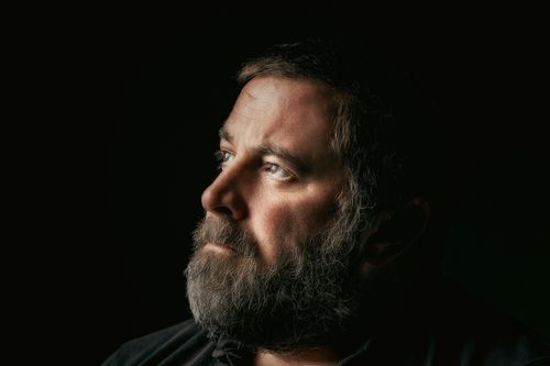 Free Dramatic side profile portrait of a bearded man looking contemplative. Stock Photo