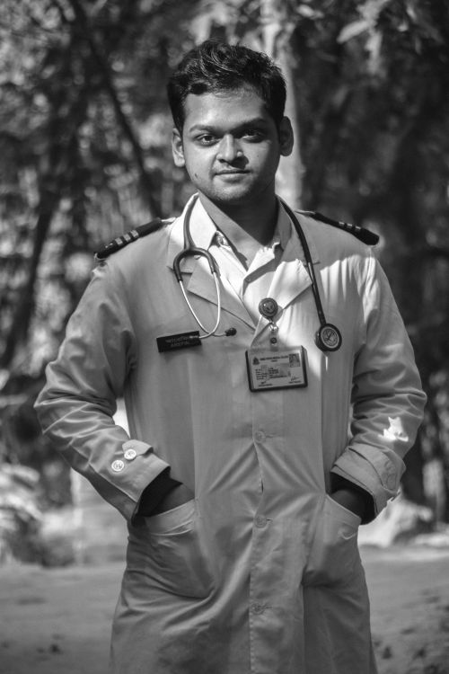 Free Black and white portrait of a smiling healthcare professional in Dhaka, Bangladesh, outdoors, with hands in pockets. Stock Photo