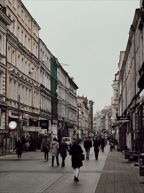 Free A vibrant street view of people walking among classic European architecture. Stock Photo