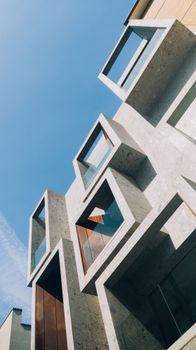 Modern building with geometric design set against a clear blue sky, showcasing contemporary architecture.