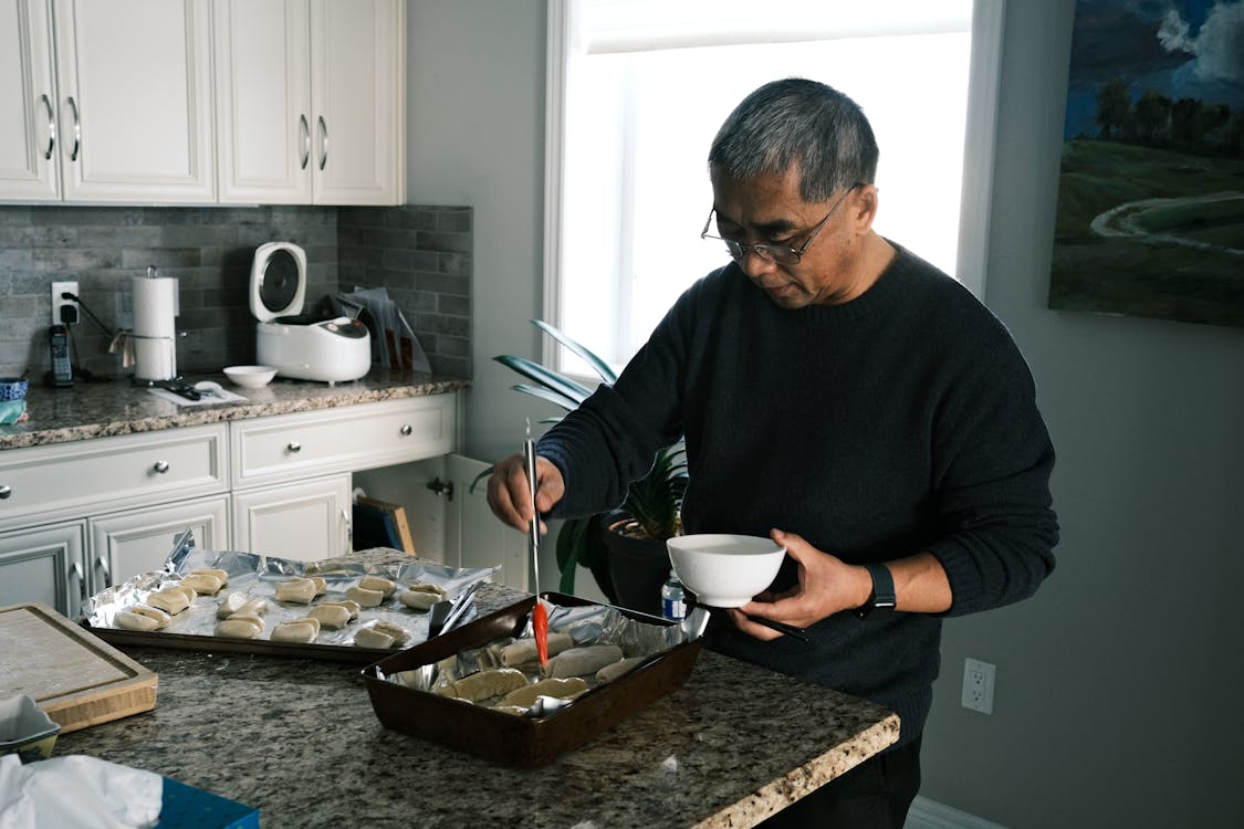 Free Focused Man Cooking in Kitchen Stock Photo