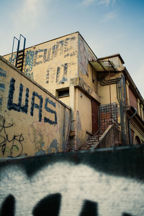 Free A neglected building in Bologna showcasing urban decay and vibrant graffiti art. Stock Photo