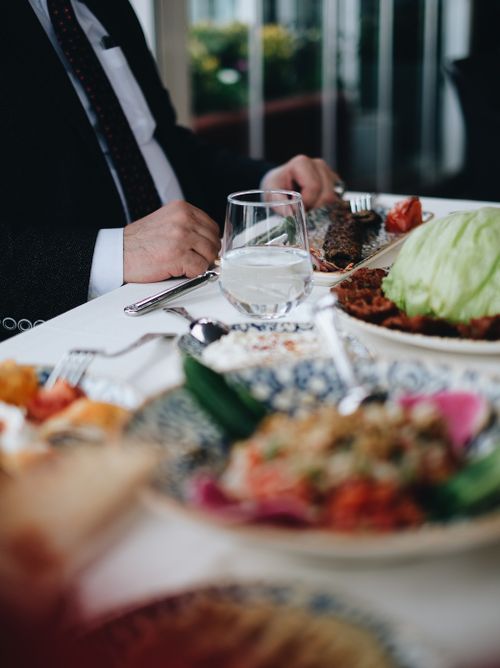 Free Close-up of a formal dining table with elegantly presented meals and glassware in a restaurant. Stock Photo