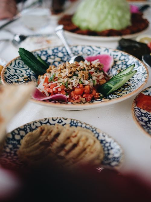 Free Delicious Mediterranean salad served on an intricately designed plate with fresh vegetables. Stock Photo