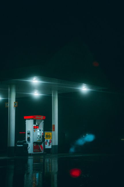 A dimly lit gas station at night, capturing a moody and dramatic atmosphere.