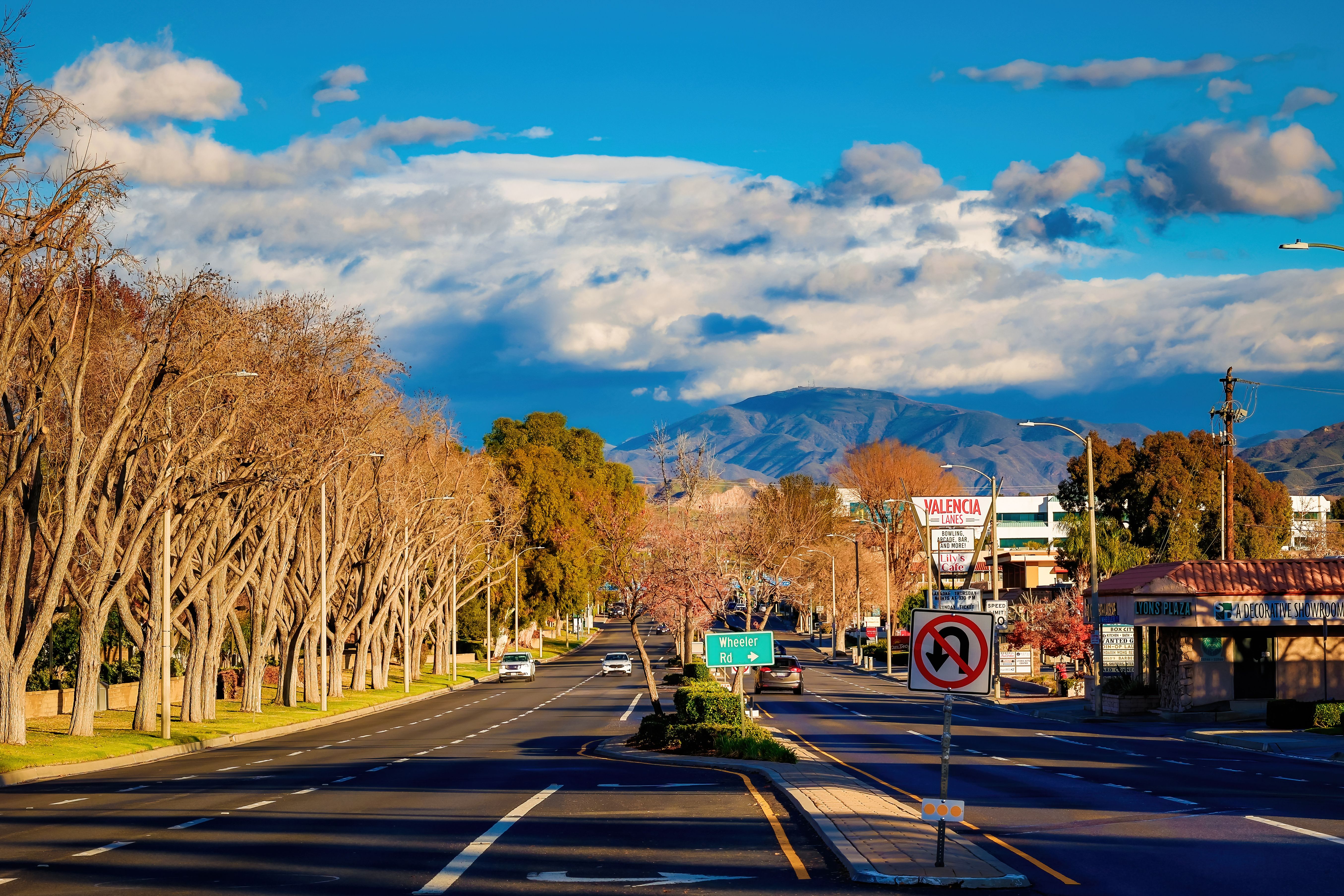 Quiet city street with distant mountains and blue sky, ideal for urban scenes.