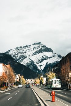 A picturesque winter scene of Cascade Mountain in Banff, Alberta, with a bustling street below.