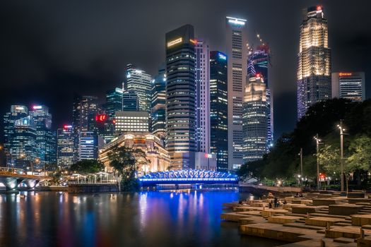 Captivating night view of Singapore's illuminated skyscrapers reflecting on the waterfront.