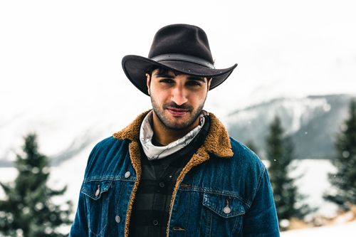 Free A rugged man in a cowboy hat poses in a snowy landscape at Jasper National Park. Stock Photo