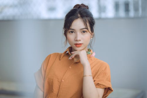Free Portrait of a Beautiful Woman Wearing an Orange Shirt Stock Photo