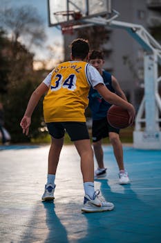 Two young athletes playing an outdoor basketball game, showcasing agility and sportsmanship.