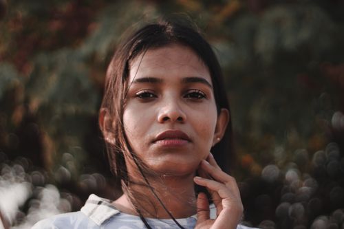 Free Captivating portrait of a young woman with a serene expression in an outdoor setting. Stock Photo