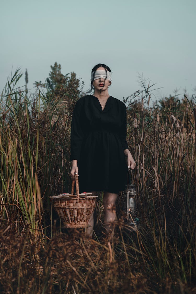 A Woman With A Blindfold In A Field