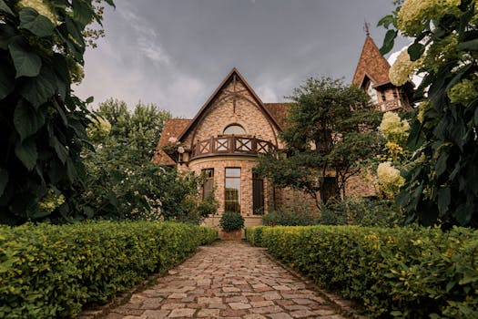 A picturesque brick house with landscaped garden and cobblestone path under a dramatic sky.