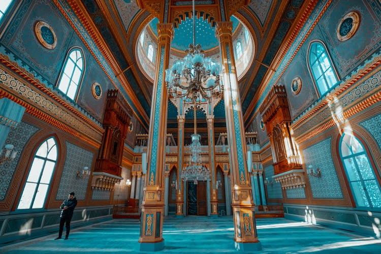 Man In Ornate Mosque Interior With Chandelier