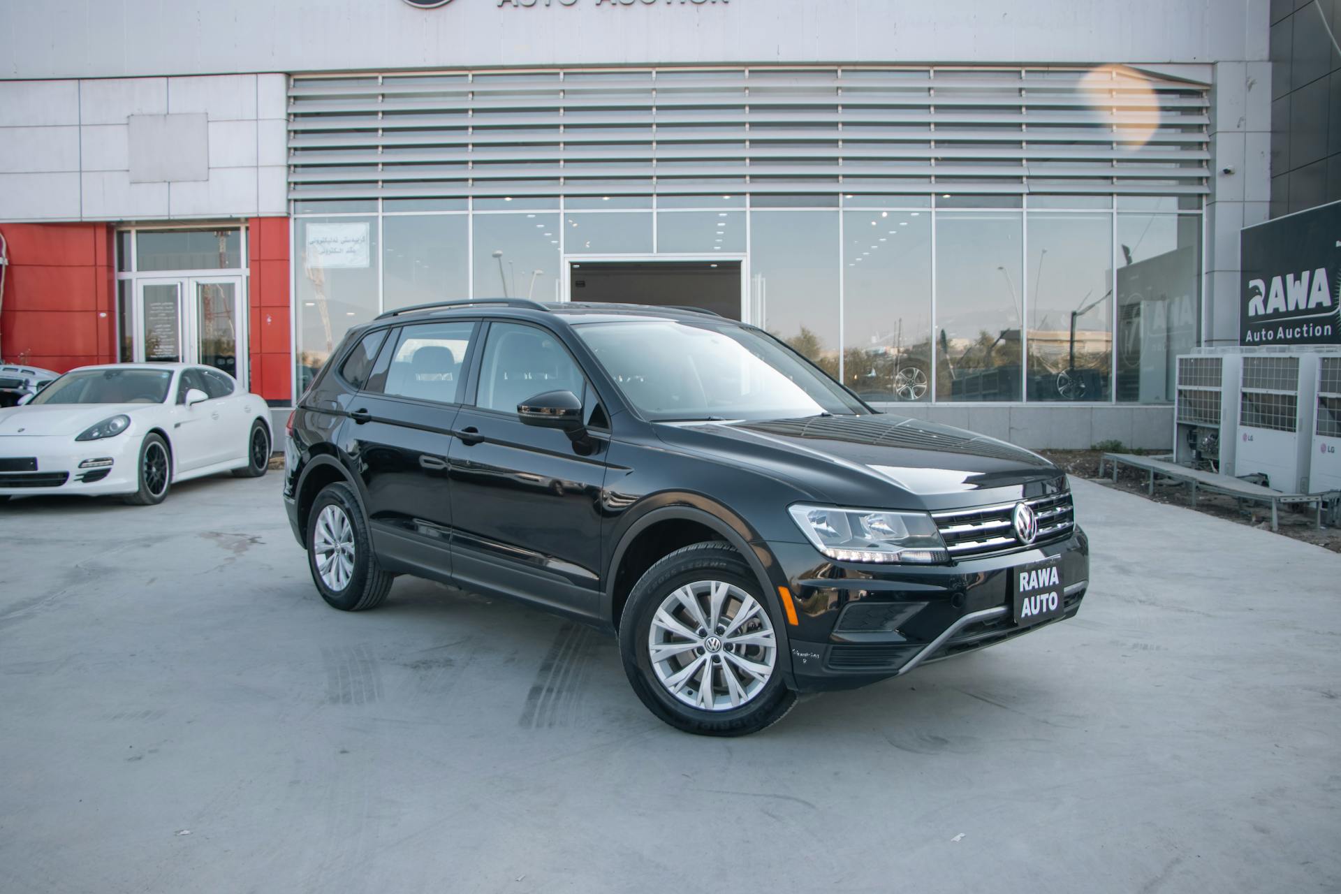 A sleek black Volkswagen SUV parked outside Rawa Auto Auction in Erbil, Iraq.