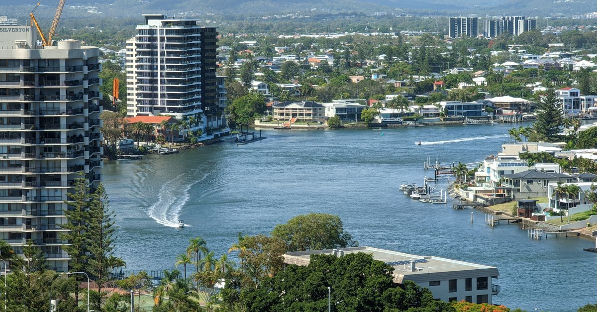 A stunning aerial view of Surfers Paradise skyline with a winding river and lush greenery.