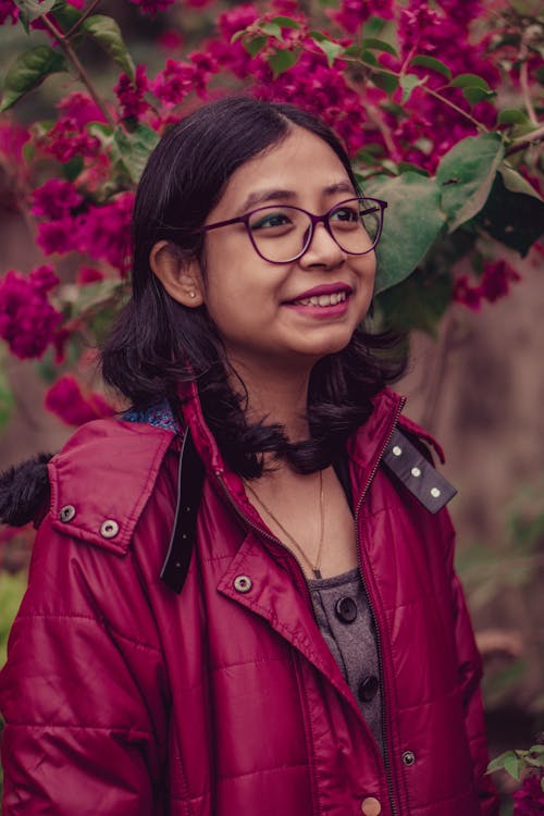Close-Up Shot of a Woman in Red Leather Jacket Wearing Eyeglasses