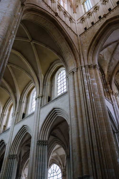 Free Stunning low-angle view of a gothic cathedral interior with soaring arches and stone columns, showcasing architectural beauty. Stock Photo