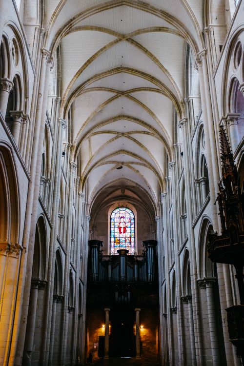 Free Gothic cathedral interior showcasing arches, columns, and stained glass window. Stock Photo