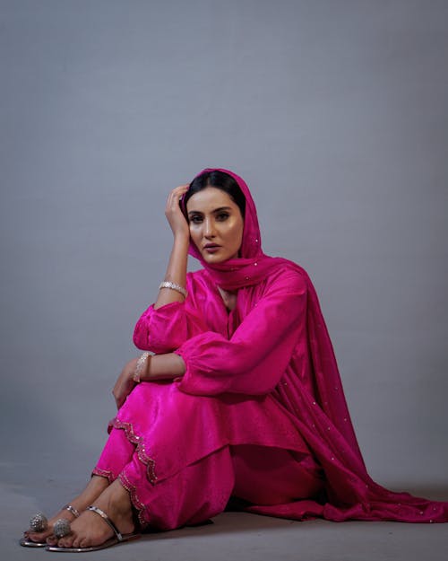 A Woman in Pink Dress Sitting on the Floor