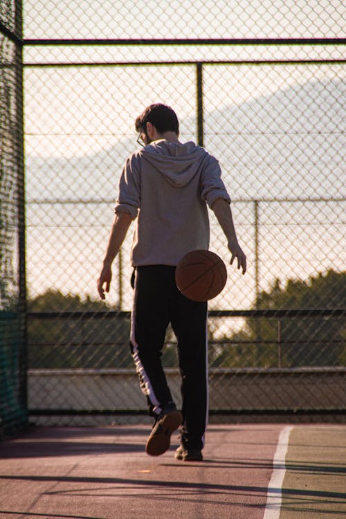 A Man in a Hoodie Playing Basketball